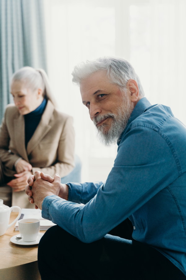 starszy wąsaty mężczyzna siedzący przy kawie z kobietą